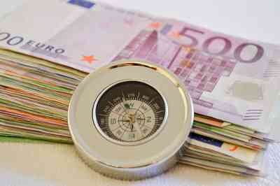 Geldscheine mit eine Kompass davor - © Martina Wendt - stock.adobe.com